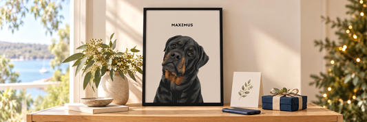 	Framed Maximus dog portrait beside a phone, Christmas card and wrapped gift.