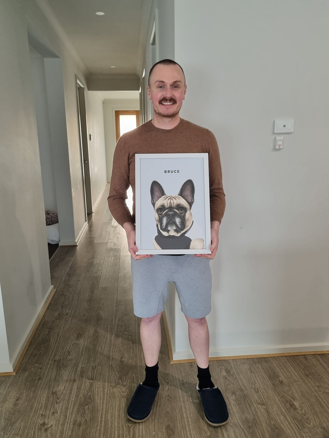 Dog owner holding a personalised framed dog portrait gift