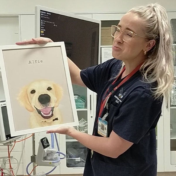 Happy customer holding a framed custom pet portrait with their dog by Oh Barney